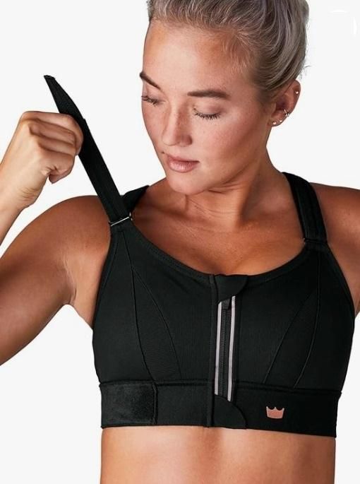 Woman wearing a black sports bra with a visible brand logo on a white background